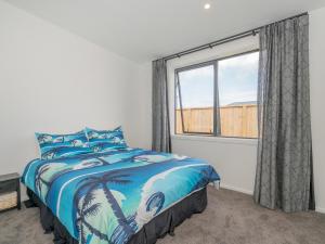 a bedroom with a bed and a window at Sun and Sea Sanctuary - Whitianga Holiday Home in Whitianga