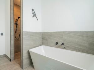 a white bath tub in a bathroom with a shower at Sun and Sea Sanctuary - Whitianga Holiday Home in Whitianga +16 photos