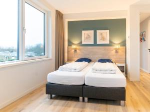 WestermientSerene Holiday Home in De Koog Texel with Sauna的有两张床的房间有两扇窗户