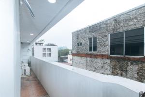 a balcony of a building with a brick wall at RedDoorz at Emperor Manila Boutique Hotel in Manila