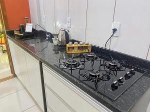 a kitchen counter with a black stove top oven at Studio 731F Conforto no Coração de Foz do Iguaçu in Foz do Iguaçu +12 photos