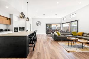 a kitchen and living room with a couch and a table at Catch & Relax - Pet Friendly - 4 Mins Walk to Beach in Callala Beach