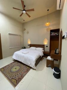 a bedroom with a bed and a ceiling fan at Thuraya chalet in Nizwa +20 photos