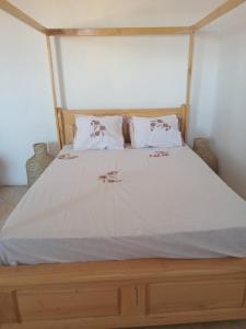 a bedroom with a large bed with white sheets and pillows at Residence wa maore in Mahajanga