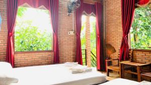 a bedroom with two beds and two windows at Nhà Nghỉ Vượn Hót in Tân Phú