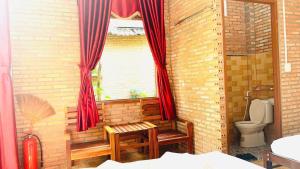 a bathroom with a toilet and a window with red curtains at Nhà Nghỉ Vượn Hót in Tân Phú +131 photos