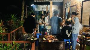 a group of people standing around a table with food at Nhà Nghỉ Vượn Hót in Tân Phú