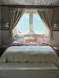 a bedroom with a large bed with a window at The Pottery Shed in Boambee