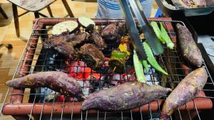 a grill with a bunch of meat and vegetables on it at Nhà Nghỉ Vượn Hót in Tân Phú
