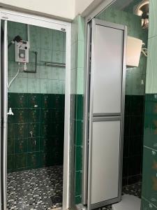 a bathroom with a shower with green tiled walls at HOMESTAY AYER MOLEK Malay ONLY in Air Molek