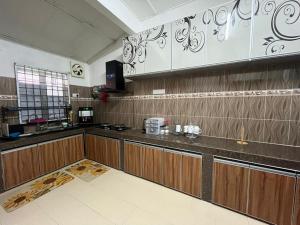 a kitchen with wooden cabinets and a counter top at HOMESTAY AYER MOLEK Malay ONLY in Air Molek