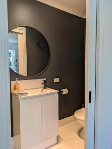 a bathroom with a sink and a mirror on the wall at Peaceful, Walk to Beach, Bikes, AC, Starlink in Byron Bay +15 photos