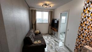 a living room with a couch and a television at Cozy apartment in a gated community in Santo André