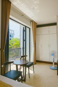 a room with a table and chairs and a large window at Square Hostel in Ha Long