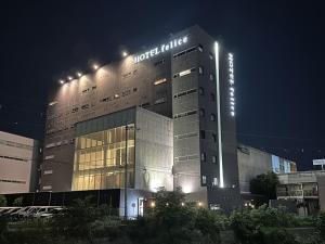HOTEL felice Osaka Itami Airport - Vacation STAY 53144v في تويوناكا: مبنى الفندق عليه لافته في الليل