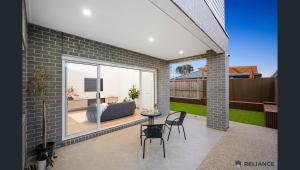 Sunbury home close to Melbourne airport في صَنبري: فناء مع طاولة وكراسي وأريكة