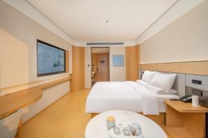 een hotelkamer met een bed en een tv bij JI Hotel Chengdu Qingbaijiang Phoenix Lake in Chengdu +37 foto's