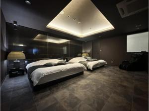 HOTEL felice Osaka Itami Airport - Vacation STAY 54171v في تويوناكا: غرفة نوم بها سريرين وتلفزيون بشاشة مسطحة