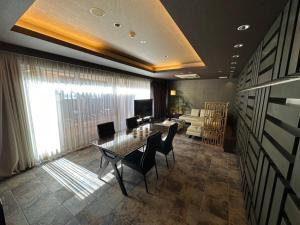 HOTEL felice Osaka Itami Airport - Vacation STAY 54171v في تويوناكا: غرفة طعام مع طاولة وكراسي وأريكة