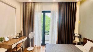 a hotel room with a bed and a large window at Phòng Double View - Chill với Máy Chiếu, Ban Công Xanh Mát in Thôn Trường Giang