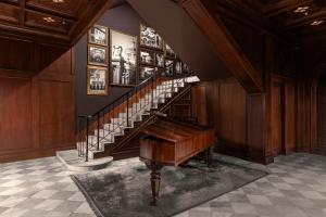a staircase with a piano in a room at Metropole, Bangkok, a Tribute Portfolio Hotel in Bangkok
