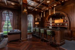 a bar with stools in a room with wooden walls at Metropole, Bangkok, a Tribute Portfolio Hotel in Bangkok