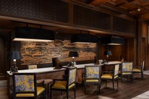 a dining room with tables and chairs and a wall at Metropole, Bangkok, a Tribute Portfolio Hotel in Bangkok
