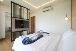 a bedroom with a white bed and a tv at Bellevue Villa Canggu in Canggu +5 photos