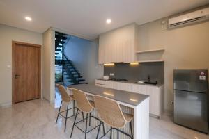 Bellevue Villa Canggu في Pererenan: مطبخ مع طاولة وكراسي في الغرفة