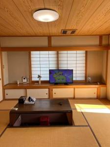 Habitación con mesa y TV. en 富士の屋河口湖, en Fujikawaguchiko