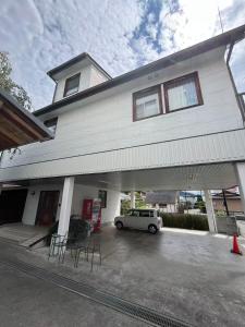 Un coche blanco aparcado delante de una casa en 富士の屋河口湖, en Fujikawaguchiko
