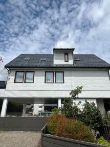 una casa blanca con techo negro en 富士の屋河口湖, en Fujikawaguchiko