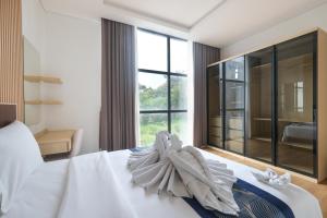 Bellevue Villa Canggu في Pererenan: غرفة نوم بسرير أبيض ونافذة كبيرة +18 صورة