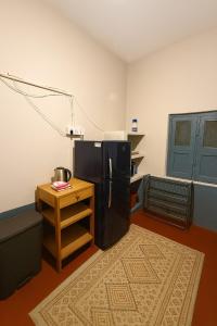 a kitchen with a black refrigerator and a table at Classic Jayanagar House for Veg only in Bengaluru +4 photos