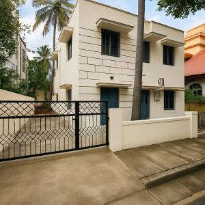 a white house with a black fence in front of it at Classic Jayanagar House for Veg only in Bengaluru