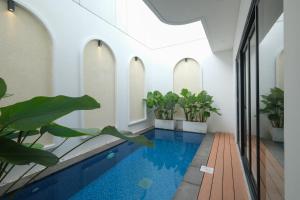 Bellevue Villa Canggu في Pererenan: مسبح داخلي في مبنى يوجد به نباتات