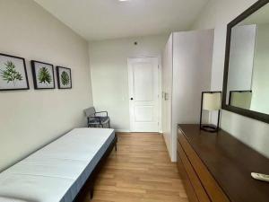 een slaapkamer met een bed, een ladekast en een spiegel bij Sweethome in Manilla +9 foto's