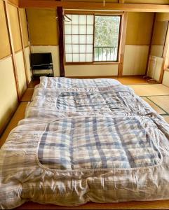 a large bed in a room with a window at ロッヂ 雪ん子 in Yuzawa
