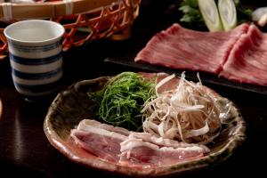 a plate of food with meat and vegetables on a table at Sui Suwako in Suwa