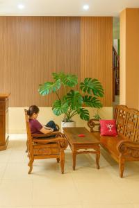 una mujer sentada en una silla en una habitación en Bảo Minh Motel, en Quang Tri