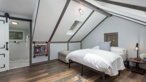 ein Schlafzimmer mit einem weißen Bett auf einem Dachboden in der Unterkunft The Biddle House by AvantStay Breathtaking Views in Lake Harmony