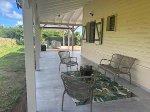 a patio with two chairs and a table on a house at Villa Jade , villa de standing proche de la plage in Le Vauclin