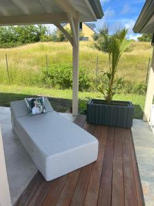 a white bed on a patio with a potted plant at Villa Jade , villa de standing proche de la plage in Le Vauclin