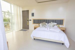 ein Schlafzimmer mit einem weißen Bett und einem großen Fenster in der Unterkunft Aqua Luna Dhangethi in Dhangethi + 2 Fotos