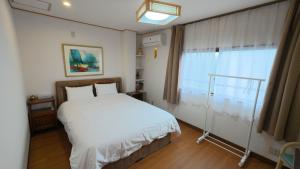 a bedroom with a white bed and a window at Rest Collection GuestOne Kyoto in Kyoto