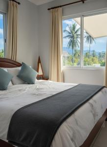 ein Schlafzimmer mit einem großen Bett mit einem großen Fenster in der Unterkunft Chon Nara Place in Thongsala