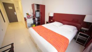 Un dormitorio con una cama grande con cabecero rojo. en Hôtel Amazonia du Fleuve***, en Saint-Laurent-du-Maroni