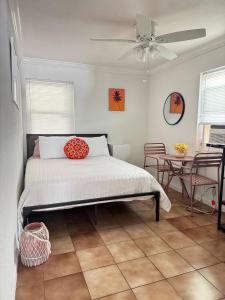 a bedroom with a bed with a ceiling fan at Cozy Little Bungalow in Fort Lauderdale