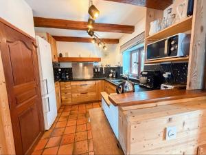 Una cocina con gabinetes de madera y encimera. en Chalet Pegulu, en Puy-Saint-Vincent 13 fotos más