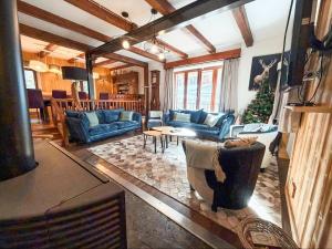una sala de estar con muebles azules y un árbol de Navidad en Chalet Pegulu, en Puy-Saint-Vincent